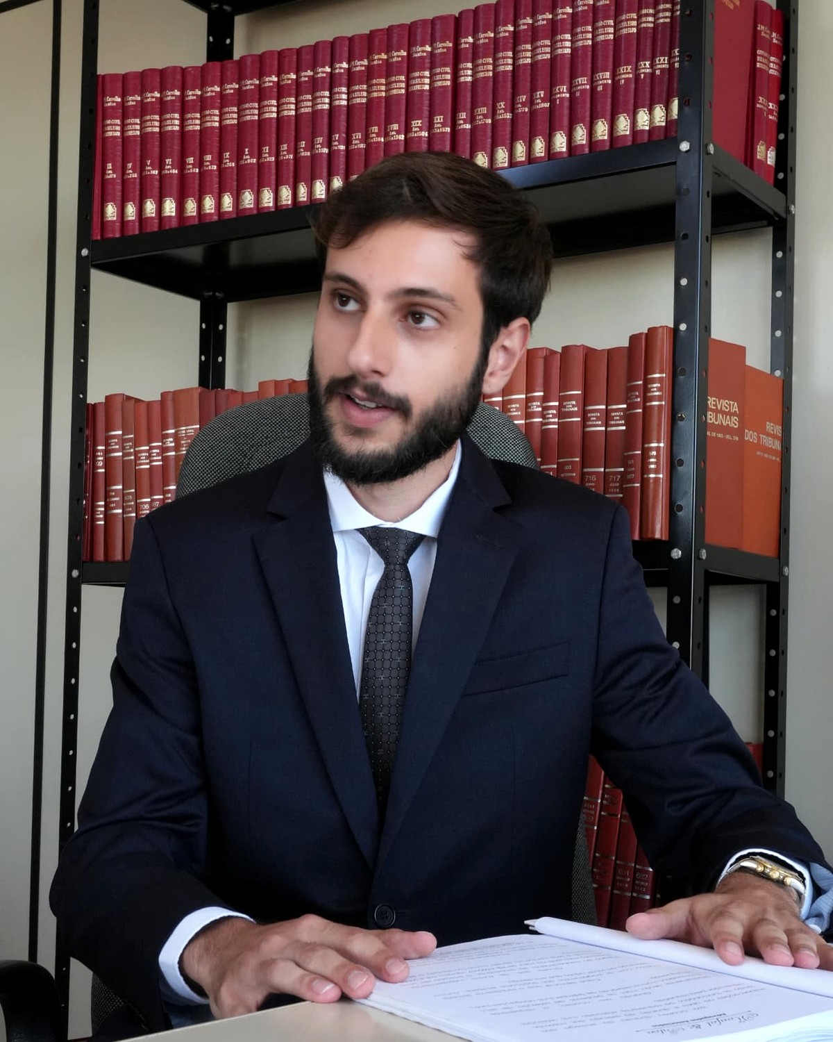 Advogado da equipe analisando um processo na biblioteca do escritório